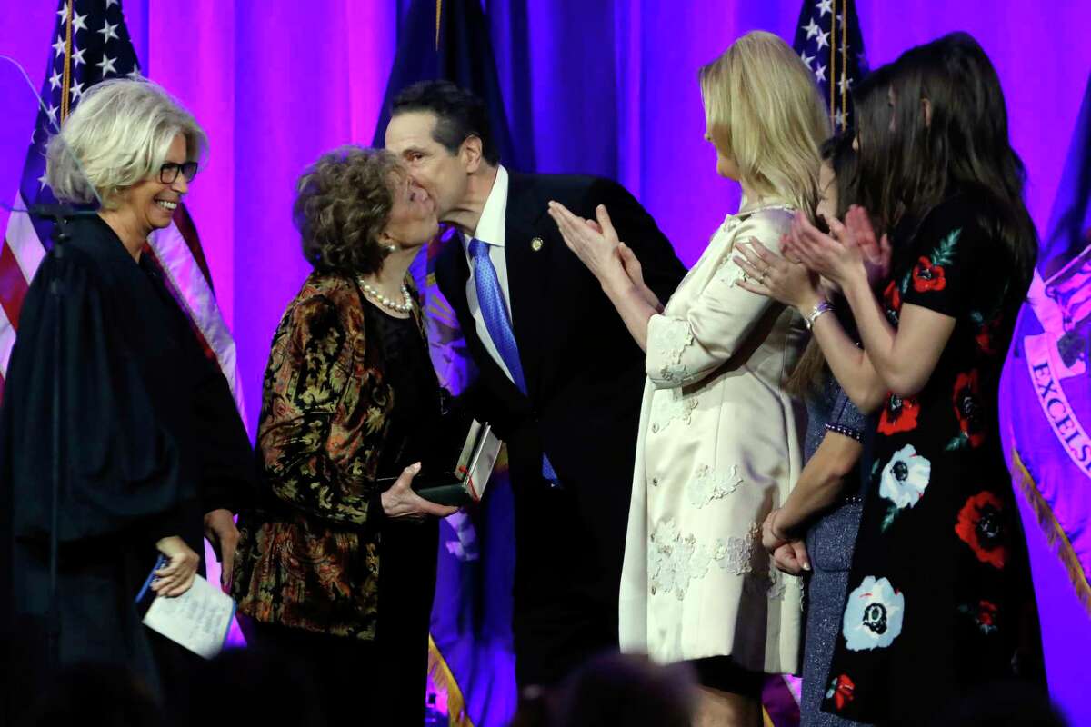New York Gov. Andrew Cuomo gets a kiss from his mother Matilda Cuomo after his third oath of office, on Ellis Island in New York harbor, Tuesday, Jan. 1, 2019.