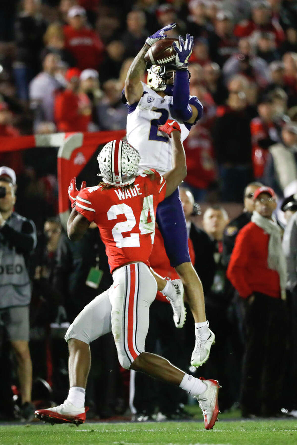 Washington wide receiver Aaron Fuller catches a pass over Ohio State cornerback Shaun Wade during the second half of the Rose Bowl NCAA college football game Tuesday, Jan. 1, 2019, in Pasadena, Calif. (AP Photo/Jae C. Hong)
