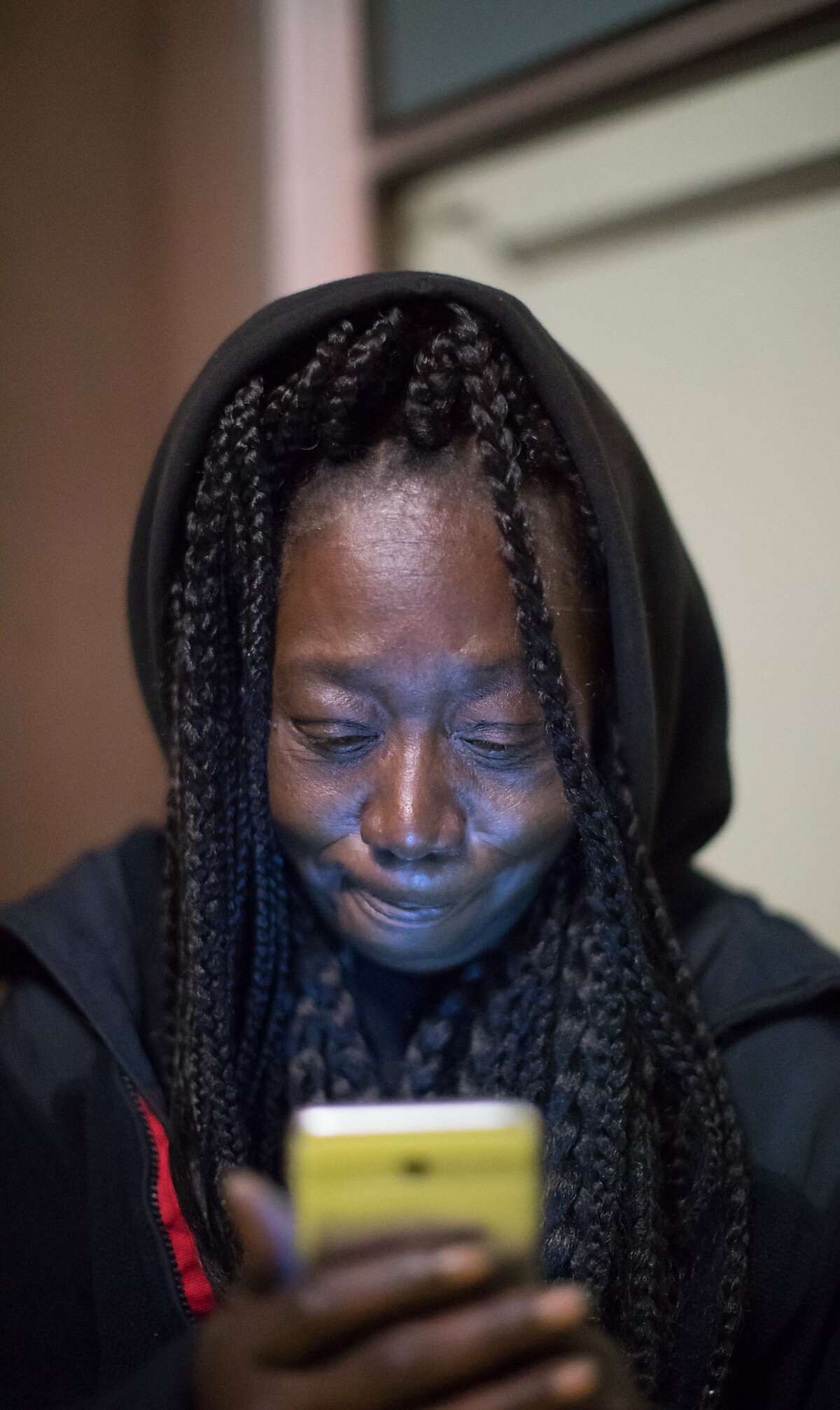 Marie McKinzie looks at her phone before going to sleep on Thursday, Dec. 20, 2018, in Oakland, Calif.
