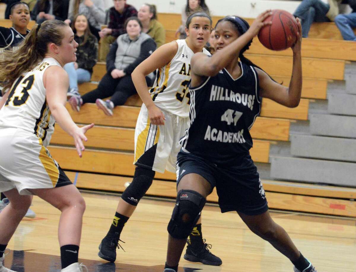 Hillhouse’s Justice Austin (41) looks to make a pass while defended by Amity’s Leia Foyer (43) on Wednesday in Woodbridge. Hillhouse won 54-45.
