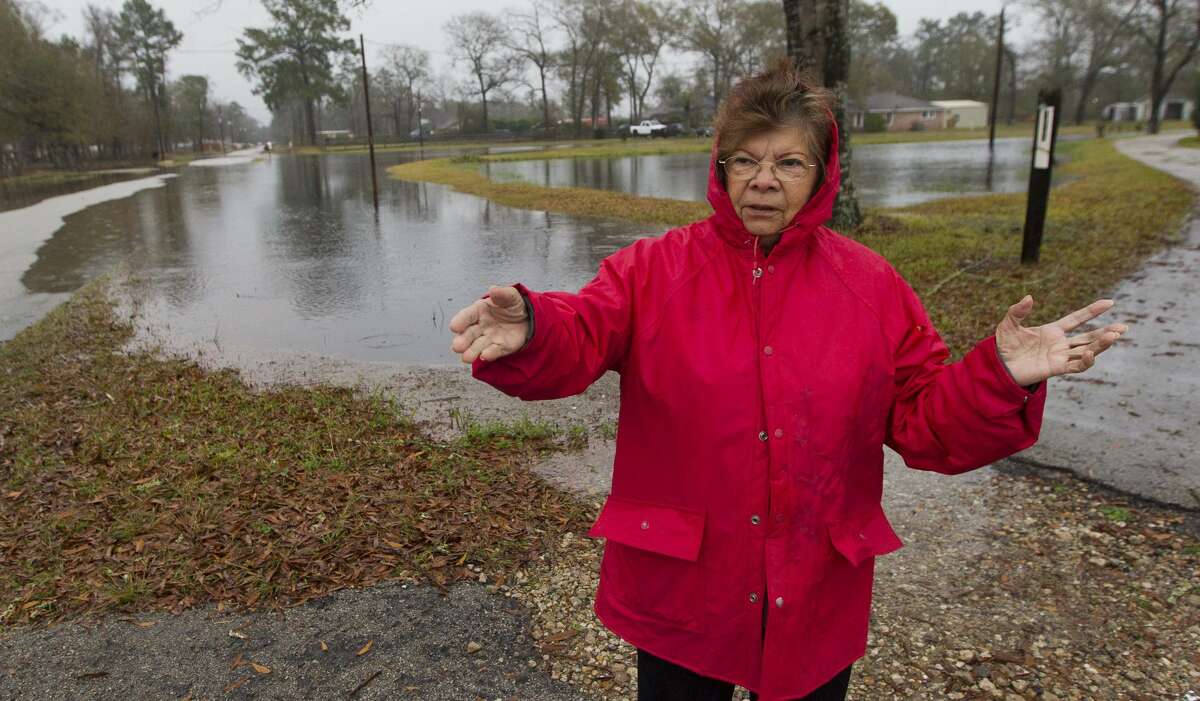 Nacy Alaniz points out flooding around her home after heavy rains continue to flood portions of Greenbough Street, Thursday, Jan. 3, 2019, in Conroe.