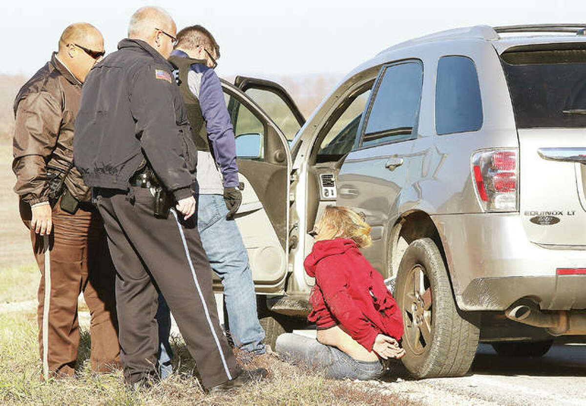 Police officers question the female occupant of a Chevrolet Equinox Thursday morning who took Alton police, and other agencies, on a more than 40-mile, high-speed chase from TheBANK of Edwardsville drive-through window in Alton to just west of the intersection of Illinois routes 16 and 100 in Jersey County, six miles from Hardin. Police received a call that the woman was allegedly trying to pass a forged check and she fled when Alton Police Sgt. William Brantley arrived and got out of his car. There was a male passenger in the Equinox, which exceeded 100 miles per hour for most of the pursuit.