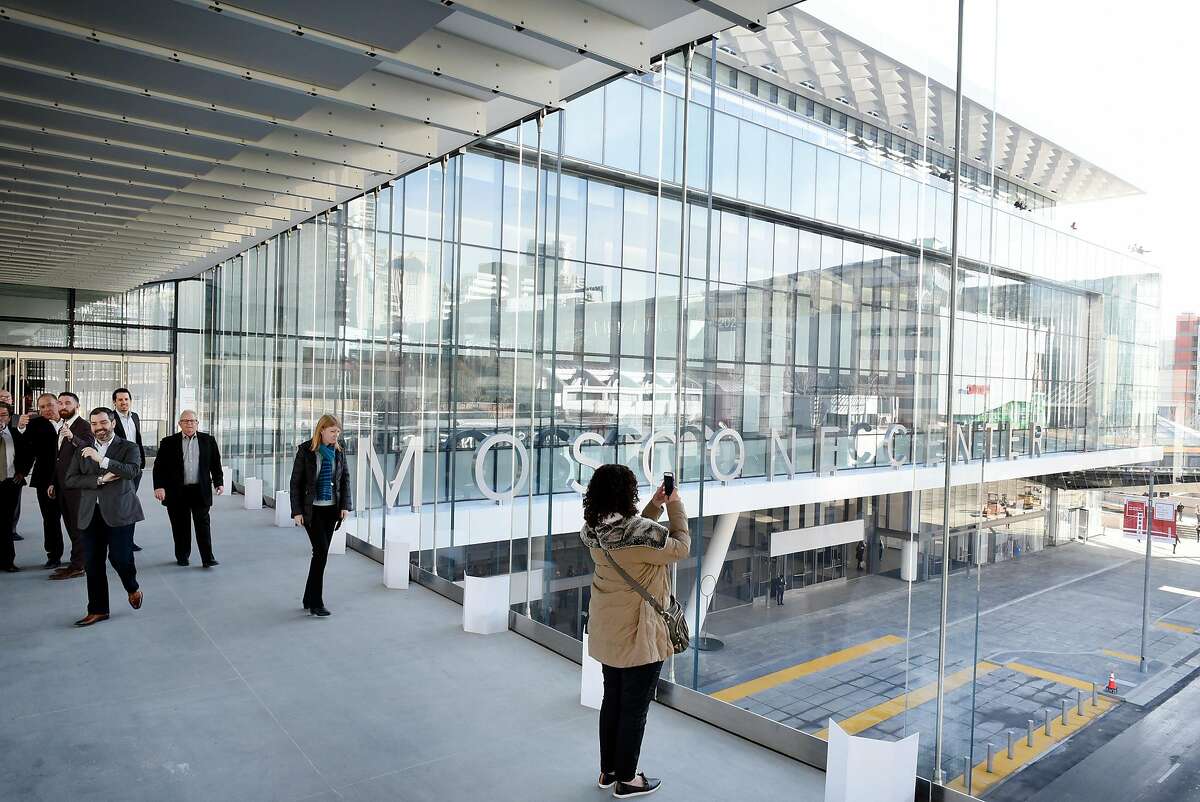 Guests take pictures from a new pedestrian walkway that connects the Moscone North and South buildings across Howard St., during a grand re-opening of the newly renovated Moscone Center in San Francisco, Calif., on Thursday, January 3, 2019.