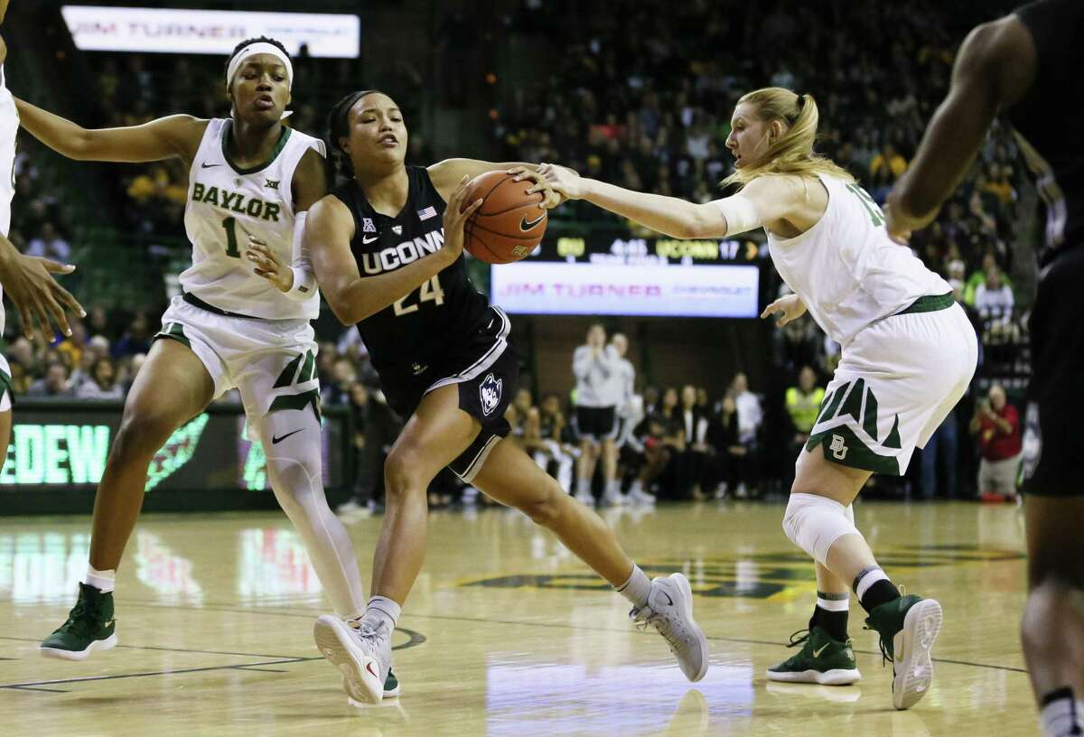 UConn’s Napheesa Collier (24) dribbles between Baylor’s NaLyssa Smith (1) and Lauren Cox (15) during the Thursday night’s in Waco, Texas.