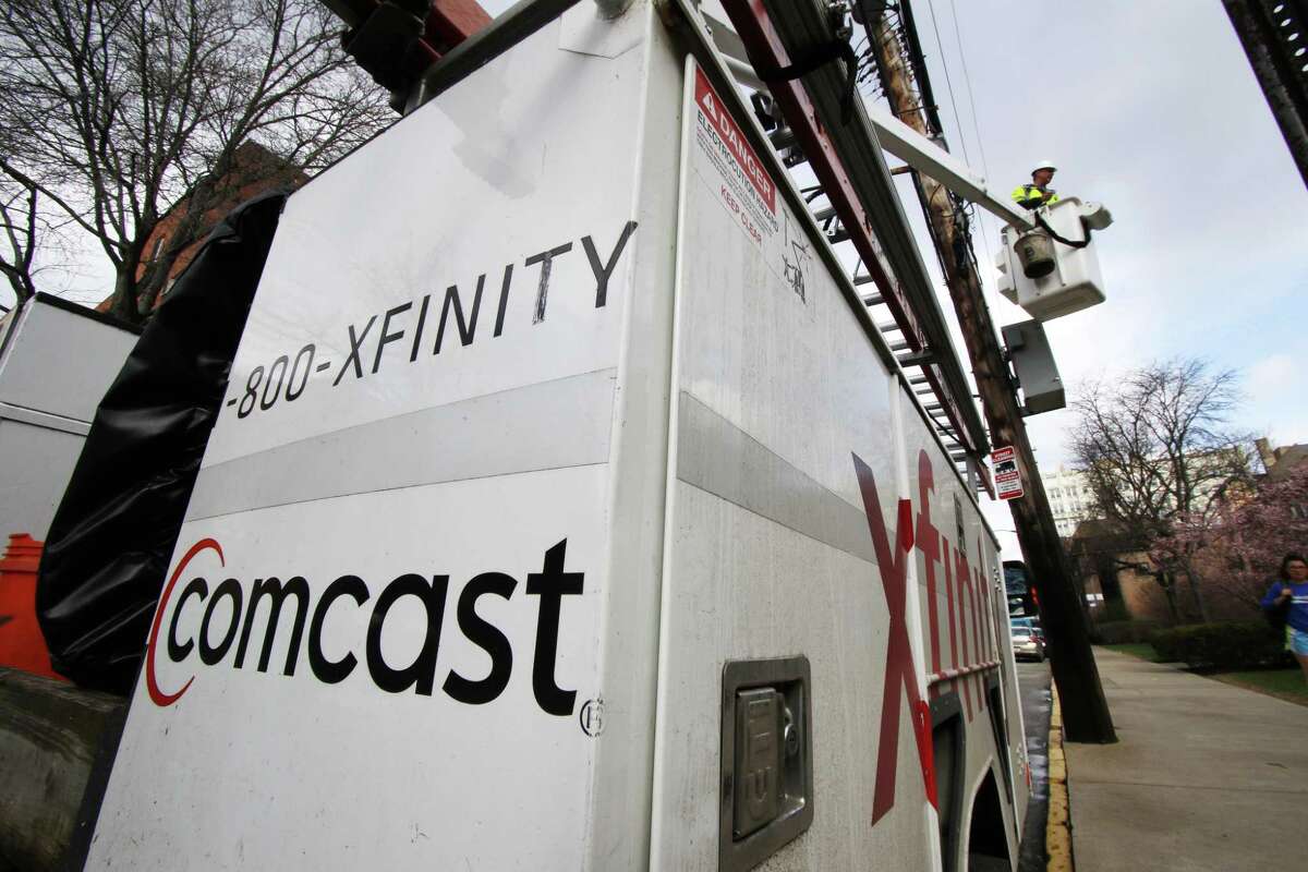 FILE- In this March 27, 2017, file photo, a Comcast worker performs work in Pittsburgh. NEXT: Who needs cable? See what original series and movies are coming to Netflix this month.
