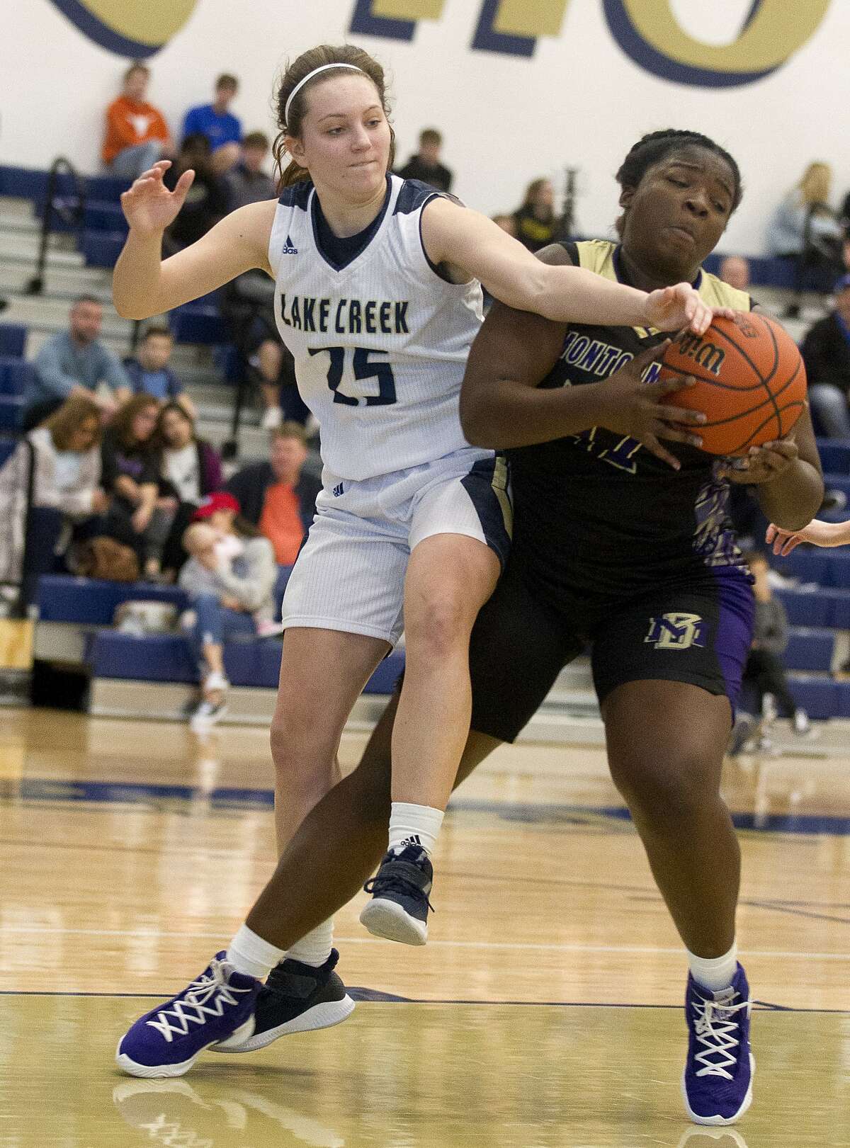 Lake Creek guard Natalie Murdock (25) reaches for a rebound against Montgomery center Deshayla Mallard (42) during the second quarter of a District 20-5A basketball game at Lake Creek High School, Friday, Jan. 4, 2018, in Montgomery.