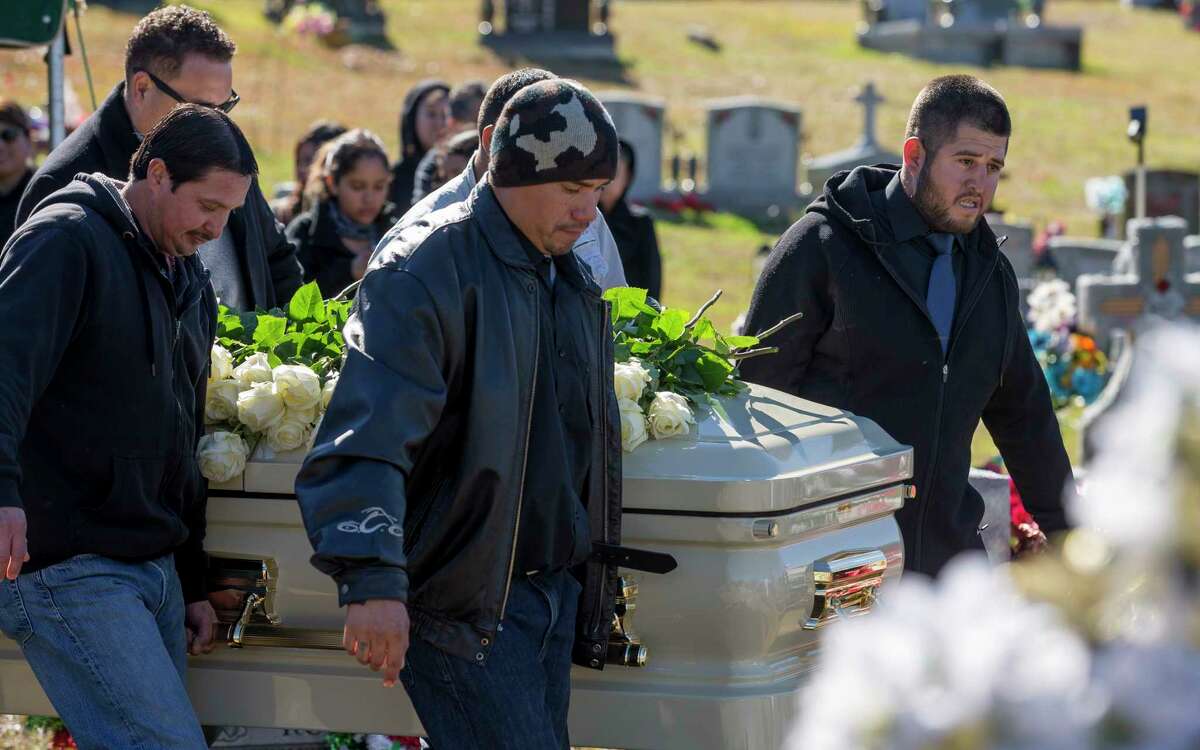 Luis Gaspar, 24, right, carries the casket of his mother, Silvia Zavala, during burial services at Hollywood Cemetery.