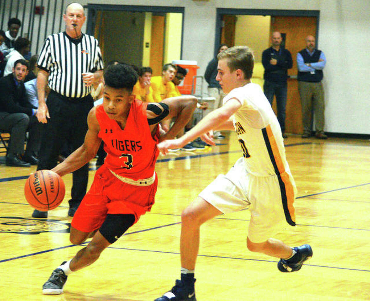 Edwardsville senior Malik Robinson, left, drives to the basket during the fourth quarter of Friday’s game at O’Fallon.