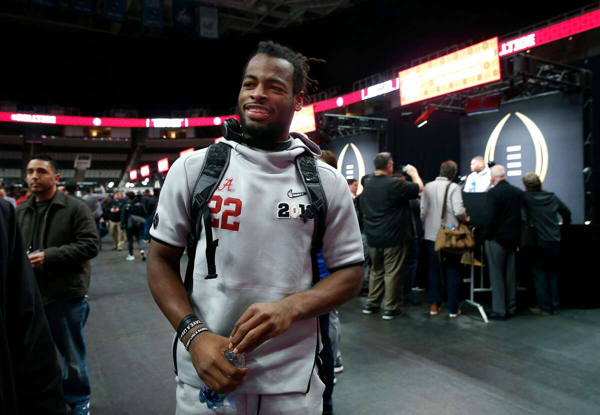 Alabama Crimson Tide running back Najee Harris walks through a throng of sports reporters at the College Football Playoff National Championship media day at the SAP Center in San Jose, Calif. on Saturday, Jan. 5, 2019.