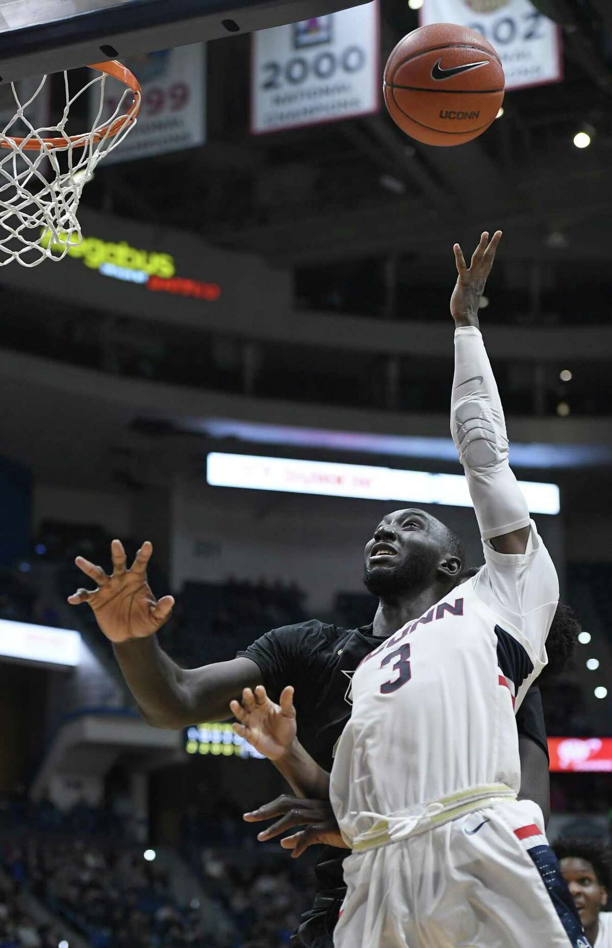 UConn’s Alterique Gilbert, right, goes up for a basket as UCF’s Tacko Fall defends during the second half on Saturday.