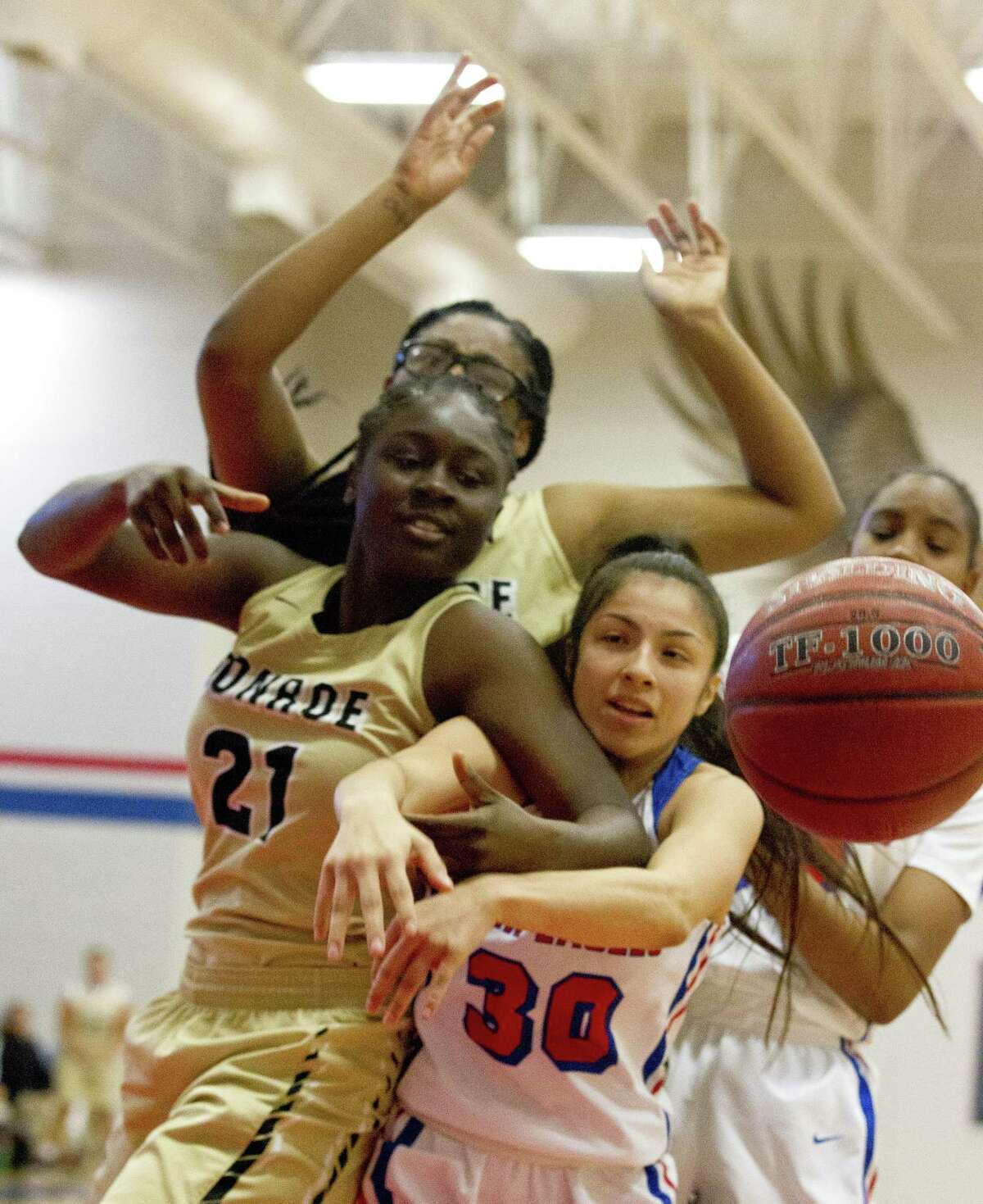 Conroe power forward Dee Anderson (21) and Oak Ridge point guard Alyssa Gonzales (30) go after a rebound during the first quarter of a District 15-6A high school basketball game at Oak Ridge High School, Saturday, Jan. 5, 2019, in Oak Ridge.