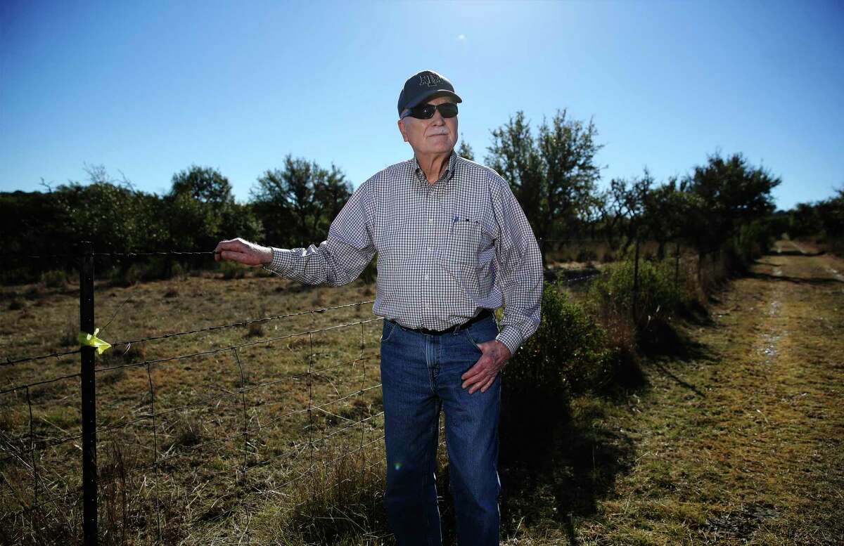 Henry Sauer stands near a fence line to show where a pipeline would potentially cross onto his property.