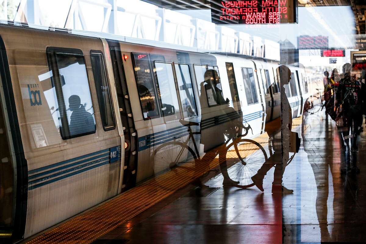 Passengers are seen through a reflection at MacArthur BART Station on Friday, November 2, 2018 in Oakland, Calif.