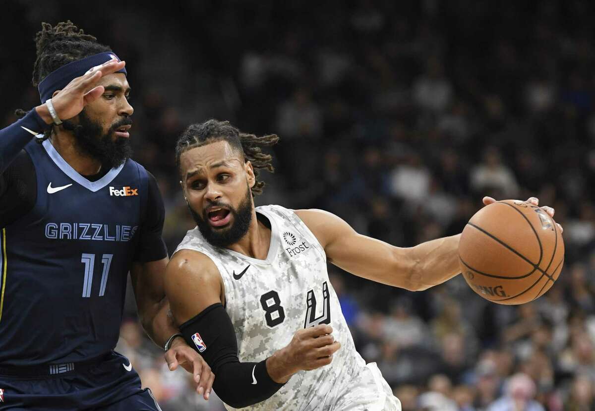 Patty Mills (8) of the San Antonio Spurs drives against Mike Conley of the Memphis Grizzlies during first-half NBA action in the AT&T Center on Saturday, Jan. 5, 2019.