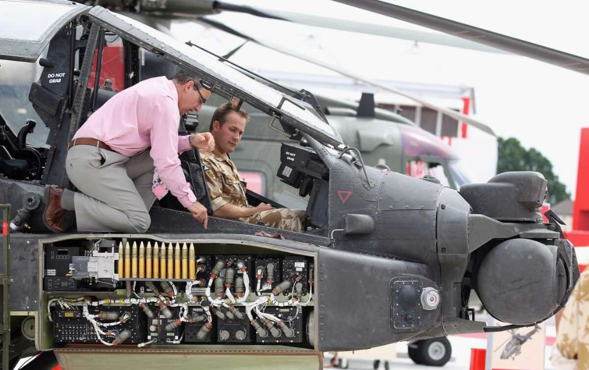 FARNBOROUGH, ENGLAND - JULY 20: A member of the public looks inside an Apache AH1 Helicopter at the Farnborough Airshow on July 20, 2010 in Farnborough, England. The Farnborough International Airshow is the biggest event of it's kind attracting people from all over the world. The show traditionally sees the announcement of orders for military jets but due to government's defence budgets being slashed to help reduce huge public deficits, major deals may be scarce. (Photo by Dan Kitwood/Getty Images)