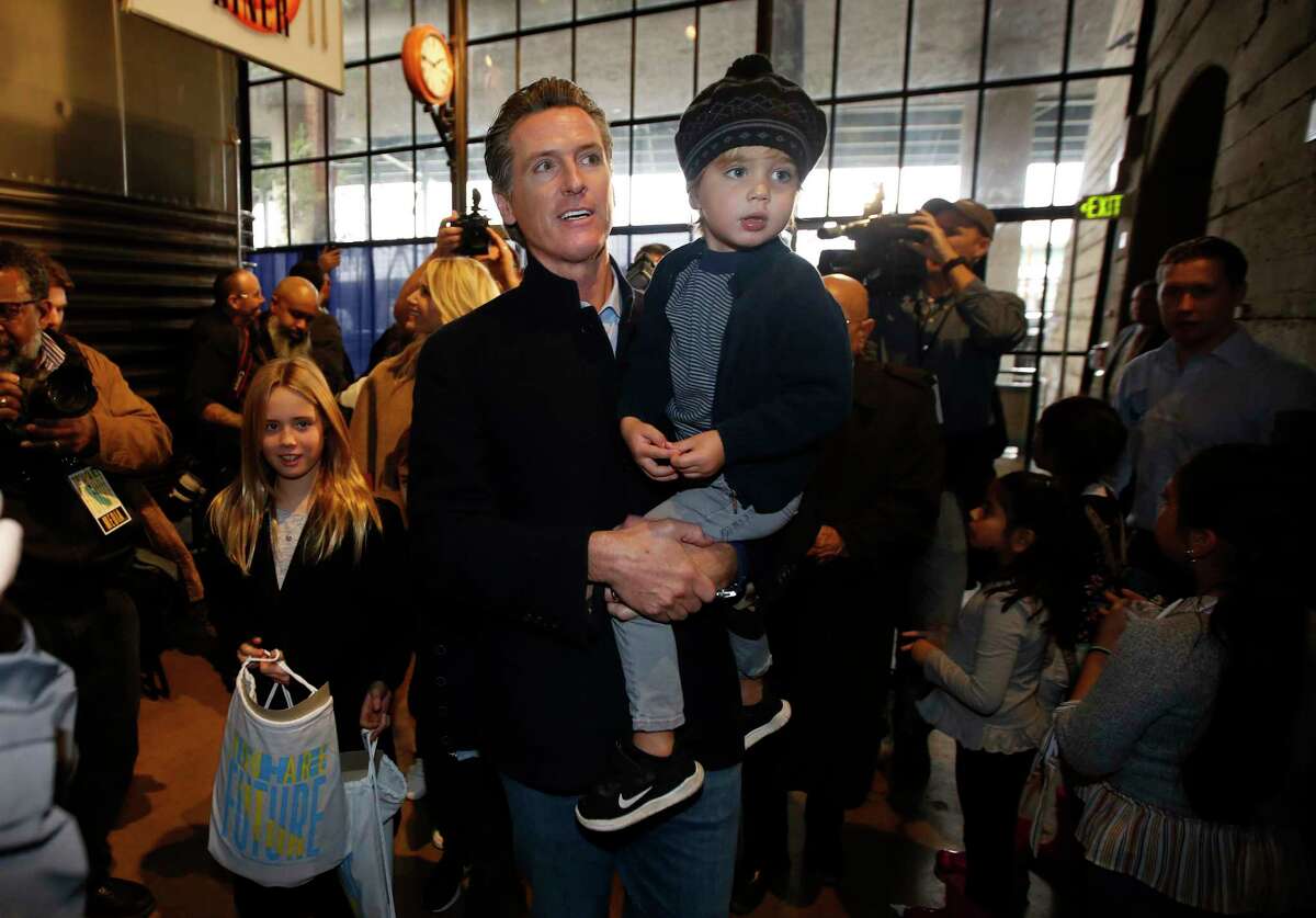 Governor-elect, Lt. Gov. Gavin Newsom, carries his son, Dutch, through the crowd during a pre-inaugural family event at the California Railroad Museum, Sunday, Jan. 6, 2019, in Sacramento, Calif. Newsom will be sworn-in as California's 40th governor, Monday.