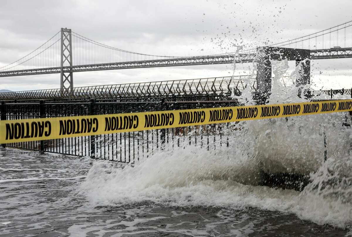 Caution tape is draped across Pier 14, closing it off to the public as large waves cause flooding along the Embarcadero in San Francisco in January 2019. The Embarcadero is expected to be impacted by king tides Sunday and Monday.