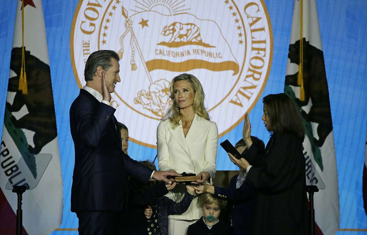 California Governor Gavin Newsom takes the oath of office from state Supreme Court Chief Justice Tani Gorre Cantil-Sakauye as his wife Jennifer Siebel Newsom looks on during his inauguration Monday, Jan. 7, 2019, in Sacramento, Calif. (AP Photo/Eric Risberg)