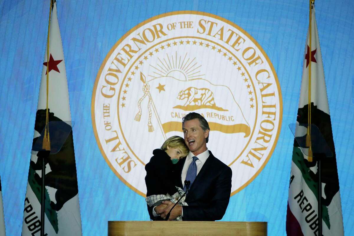 California Governor Gavin Newsom holds his son Dutch while speaking during his inauguration Monday, Jan. 7, 2019, in Sacramento, Calif.
