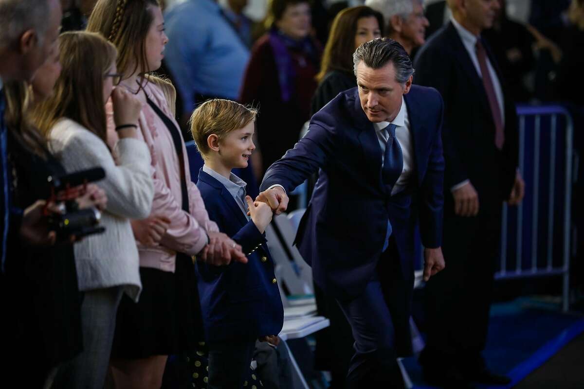 Governor-elect Gavin Newsom gives a fist bump to his son Hunter Newsom (left) ahead of taking the oath of office during his inauguration ceremony in Sacramento, California, on Monday, January 7th, 2019.