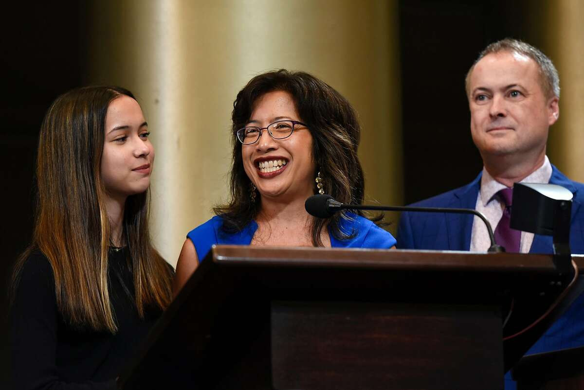 Oakland City Council member Nikki Fortunato Bas gives a speech flanked by her daughter Velana and husband Brad after being sworn in during an inauguration ceremony for elected representatives at City Hall in Oakland, Calif., on Monday, January 7, 2019.