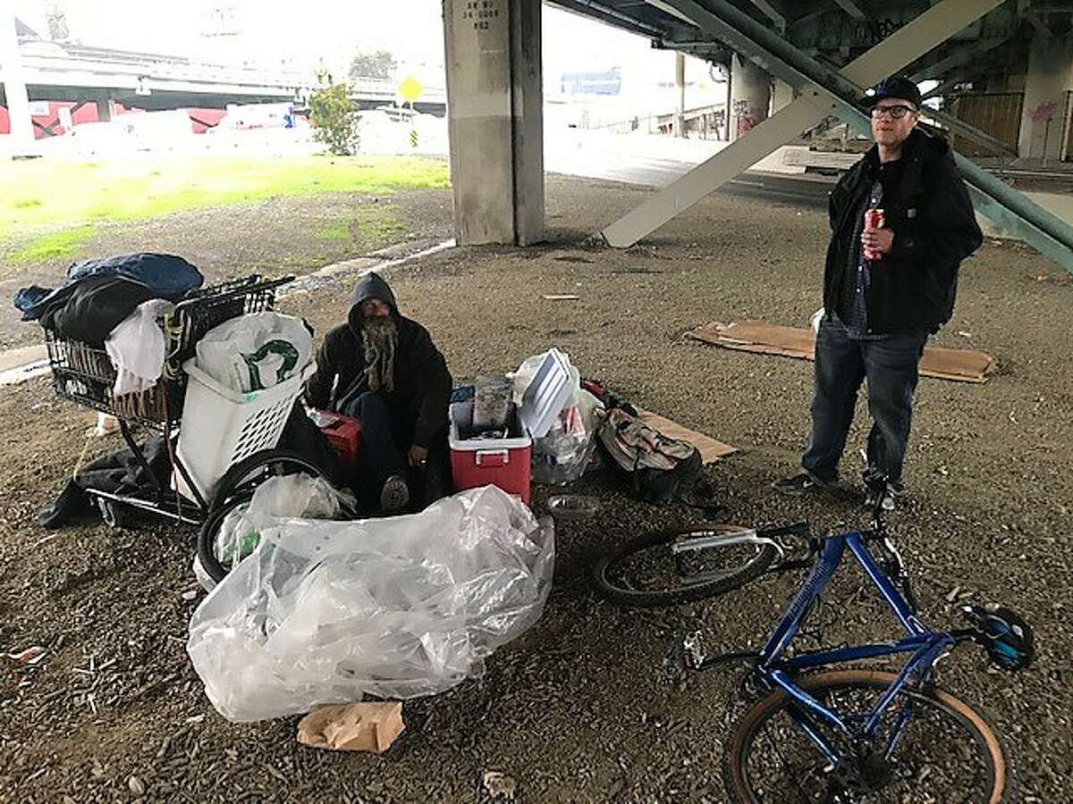 Homeless campers Niev Khabeiry, left, and Brian Martin hope they can move into San Francisco's newest Navigation Center homeless shelter, which is opening in January 2019 across the street from where they sit under the Interstate 80 freeway.