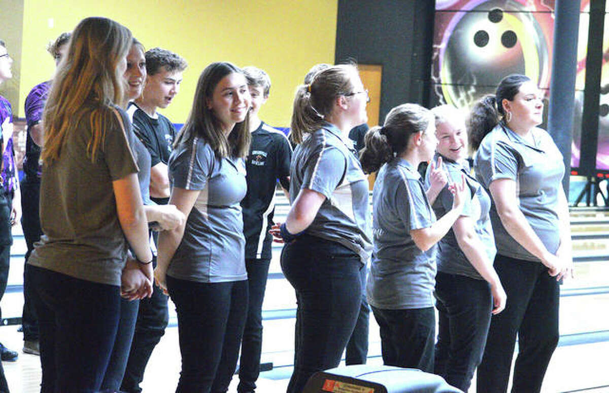 The Edwardsville girls’ bowling team lines up for the national anthem prior to Tuesday’s Southwestern Conference dual match against Collinsville at Edison’s Entertainment Center.