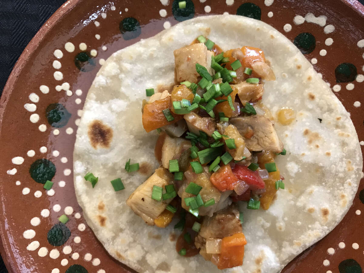 Chicken thighs and peppers in a lime butter sauce on a flour tortilla from the taco pop-up dinners hosted by Cesar Cano.