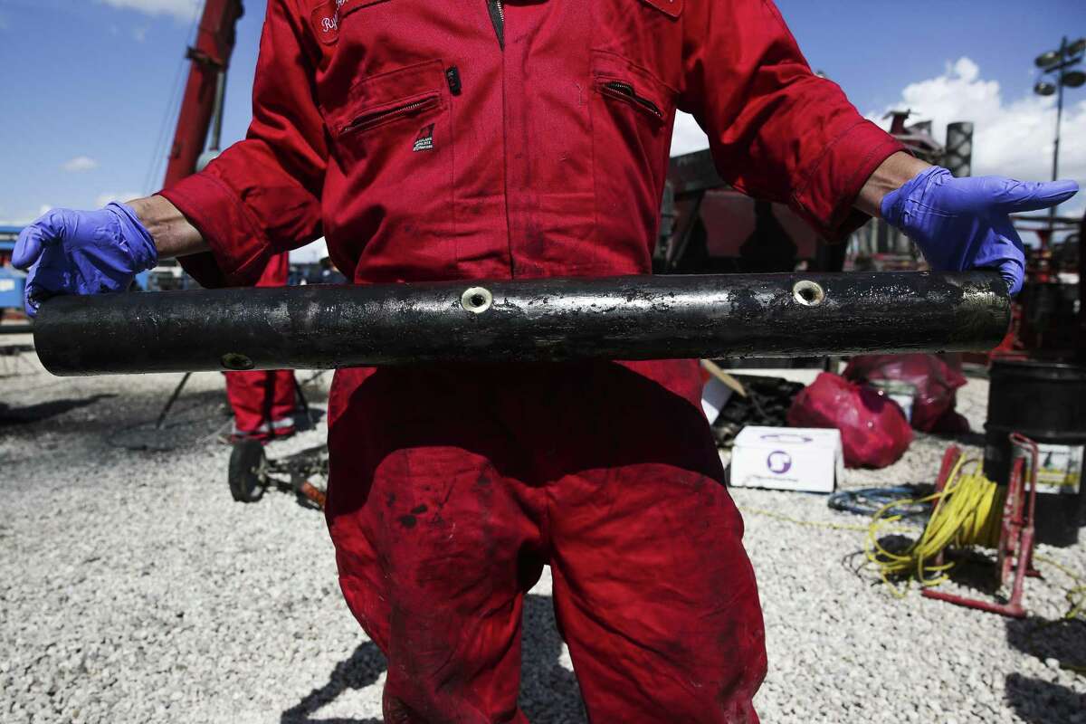A worker holds a perforation charge pipe at a Chevron drilling site. Chevron contractors will inject sand and water through the pipes holes during hydraulic fracturing operations.