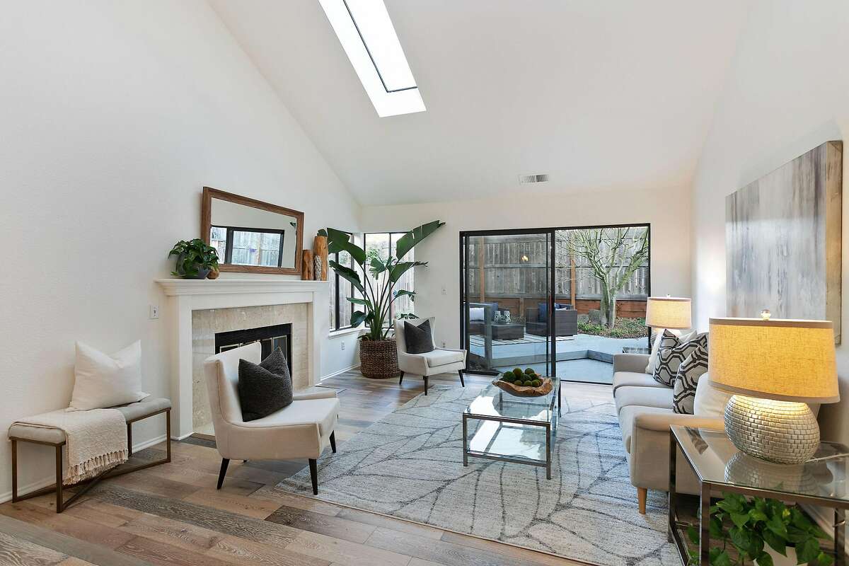 The living room of the Alameda home features a skylight, wood-burning fireplace and access to the backyard.