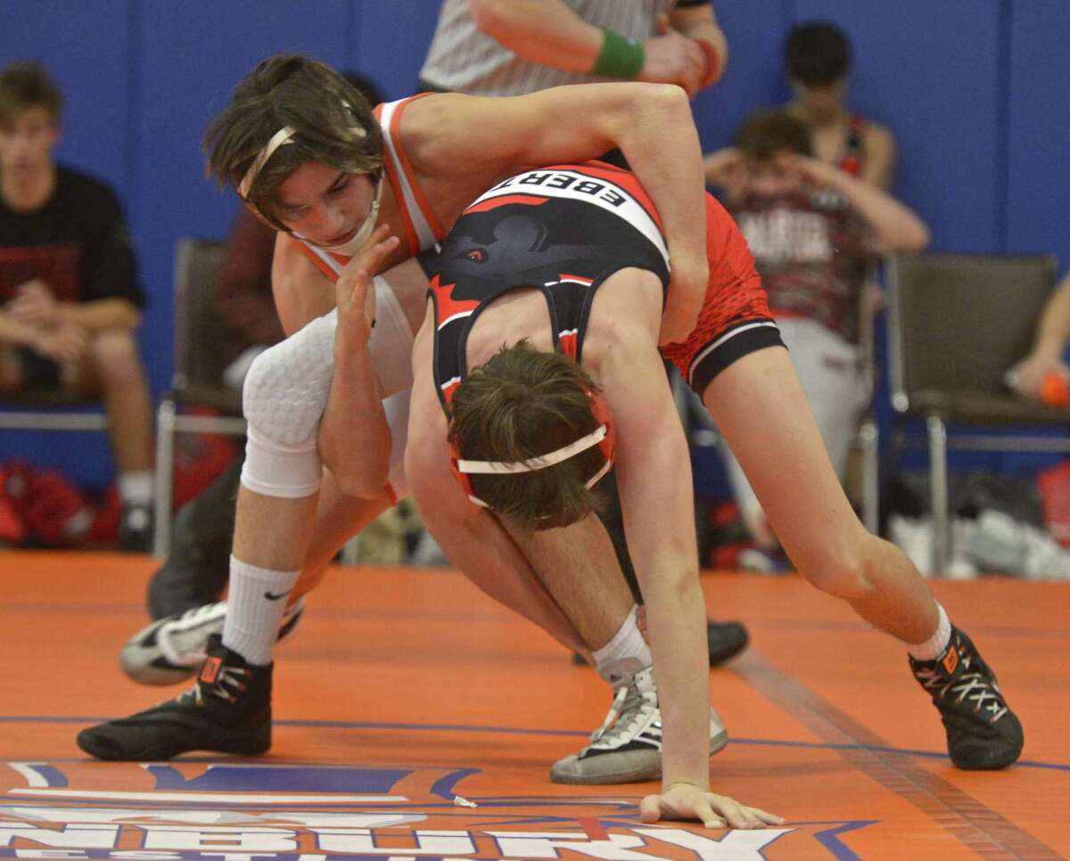 Fairfield-Warde’s William Ebert (red) and Danbury's Ryan Jack wrestle in the 126-pound weight class during a dual meet on Dec. 19 at Danbury High School.