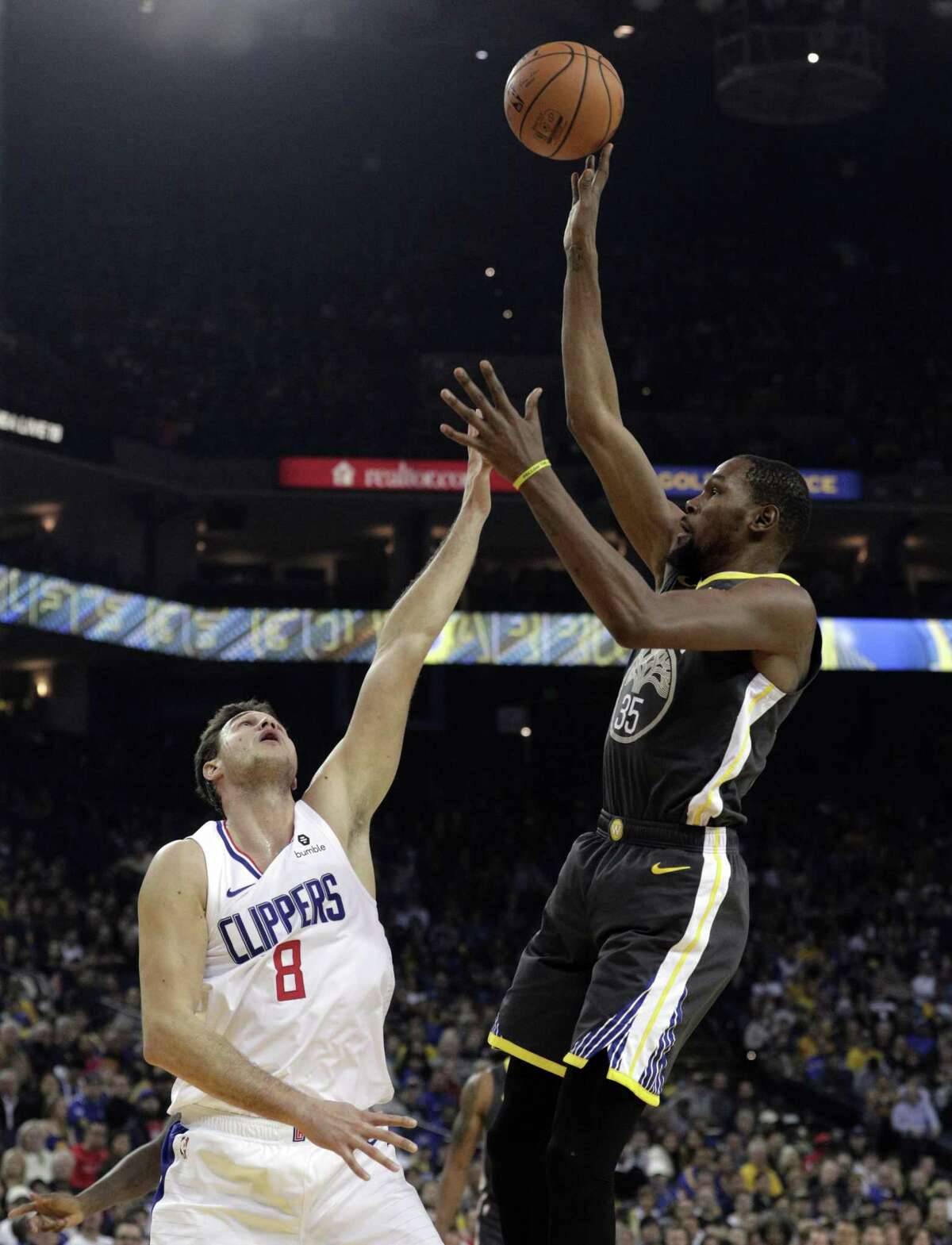 Kevin Durant (35) shoots over Danilo Gallinari (8) in the first half as the Golden State Warriors played the Los Angeles Clippers at Oracle Arena in Oakland, Calif., on Sunday, December 23, 2018.