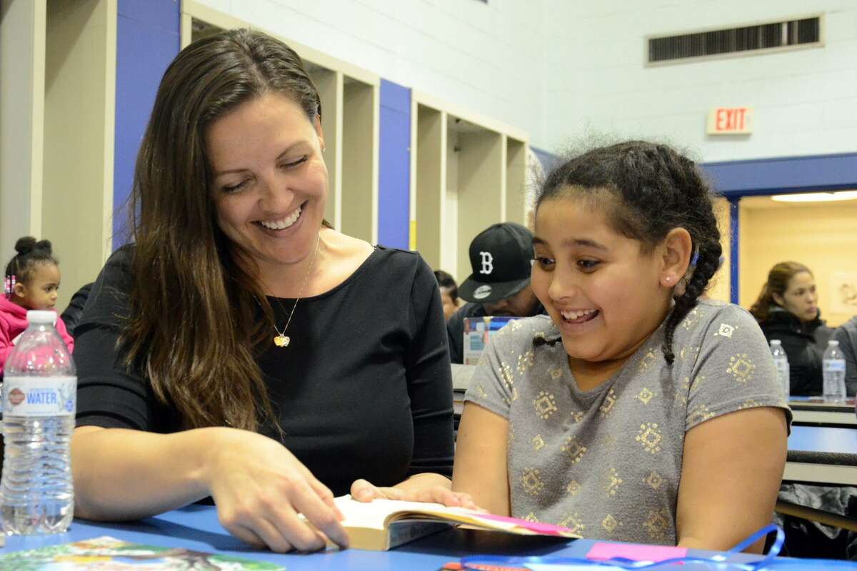 Heather Gilbertie reads a book with her daughter Sophia Freeman at Jefferson Elementary School on Thursday night.