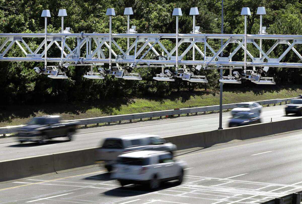Cars pass under toll sensor gantries hanging over the Massachusetts Turnpike in Newton, Mass.