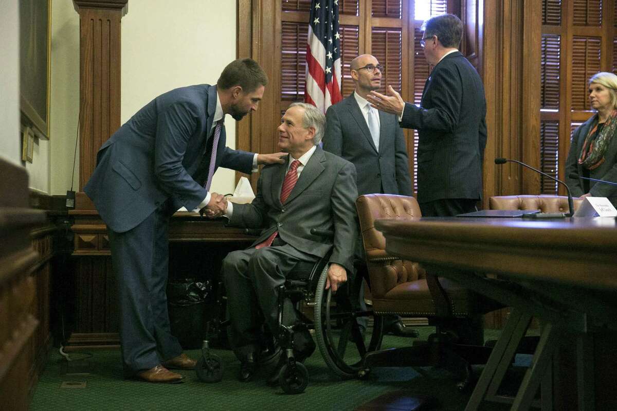 Members of the State Preservation Board, left to right, state Rep. Jeff Leach, R-Plano, Gov. Greg Abbott, House Speaker Dennis Bonnen, R-Angleton, Lt. Gov. Dan Patrick and citizen board member Aletha Swann Bugg talk to each other moments after voting to remove the Children of the Confederacy Creed plaque from the Capitol during a meeting of the State Preservation Board at the Capitol on Friday, Jan. 11, 2019, in Austin, Texas. (Jay Janner/Austin American-Statesman via AP)