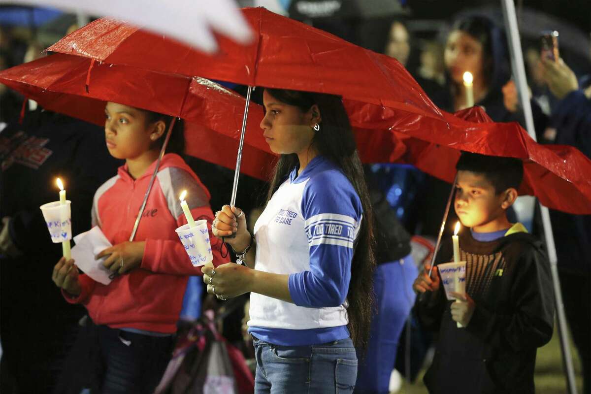 Mercedes Zamora (center) along with her sister Lexus (left) join others in attending a prayer vigil in the rain for King Jay Davila, the 8-month-old baby who has been missing for nearly a week, on Friday, Jan. 11, 2019 in Monterrey Park. On Thursday prior to tonight's vigil, law enforcement reported that the child's body was found. (Kin Man Hui/San Antonio Express-News)