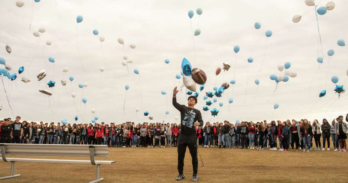 Harlan High School football player Samuel Carter center along with other students and parents release balloons at the school's football field honoring football player Shomari Anderson was killed in an auto accident on Saturday.