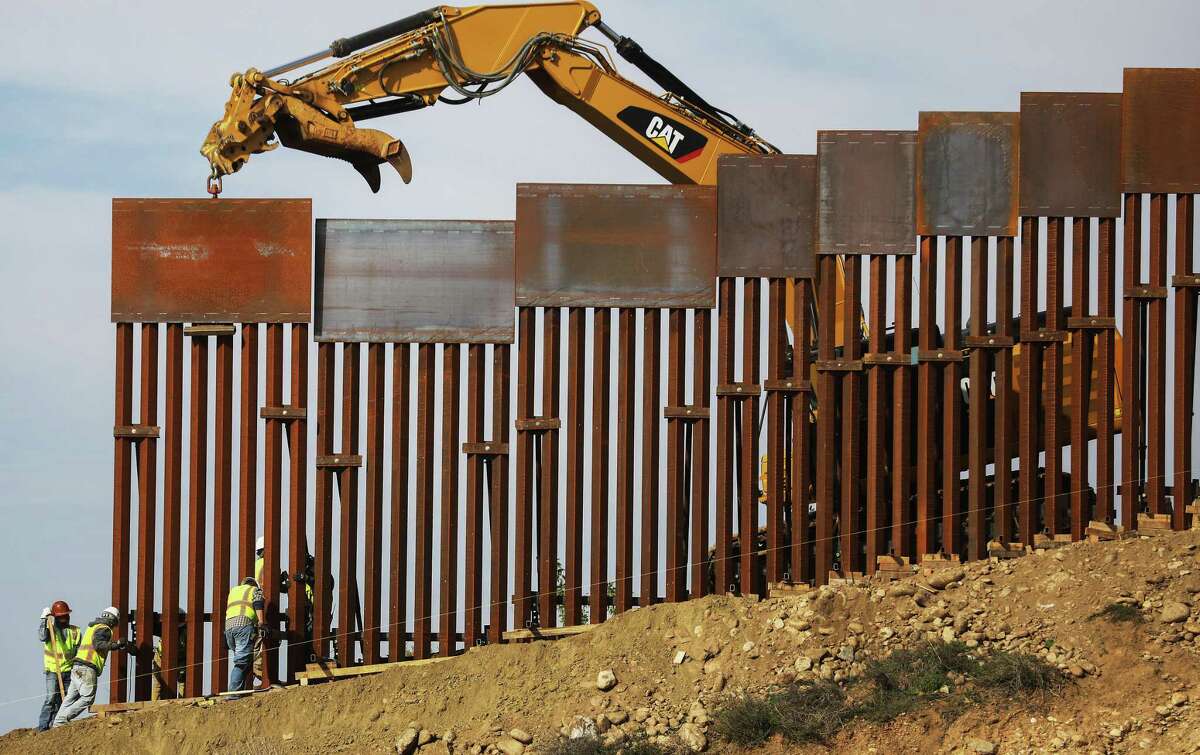A construction crew installs new sections of the U.S.-Mexico border barrier on January 11, 2019 as seen from Tijuana, Mexico.