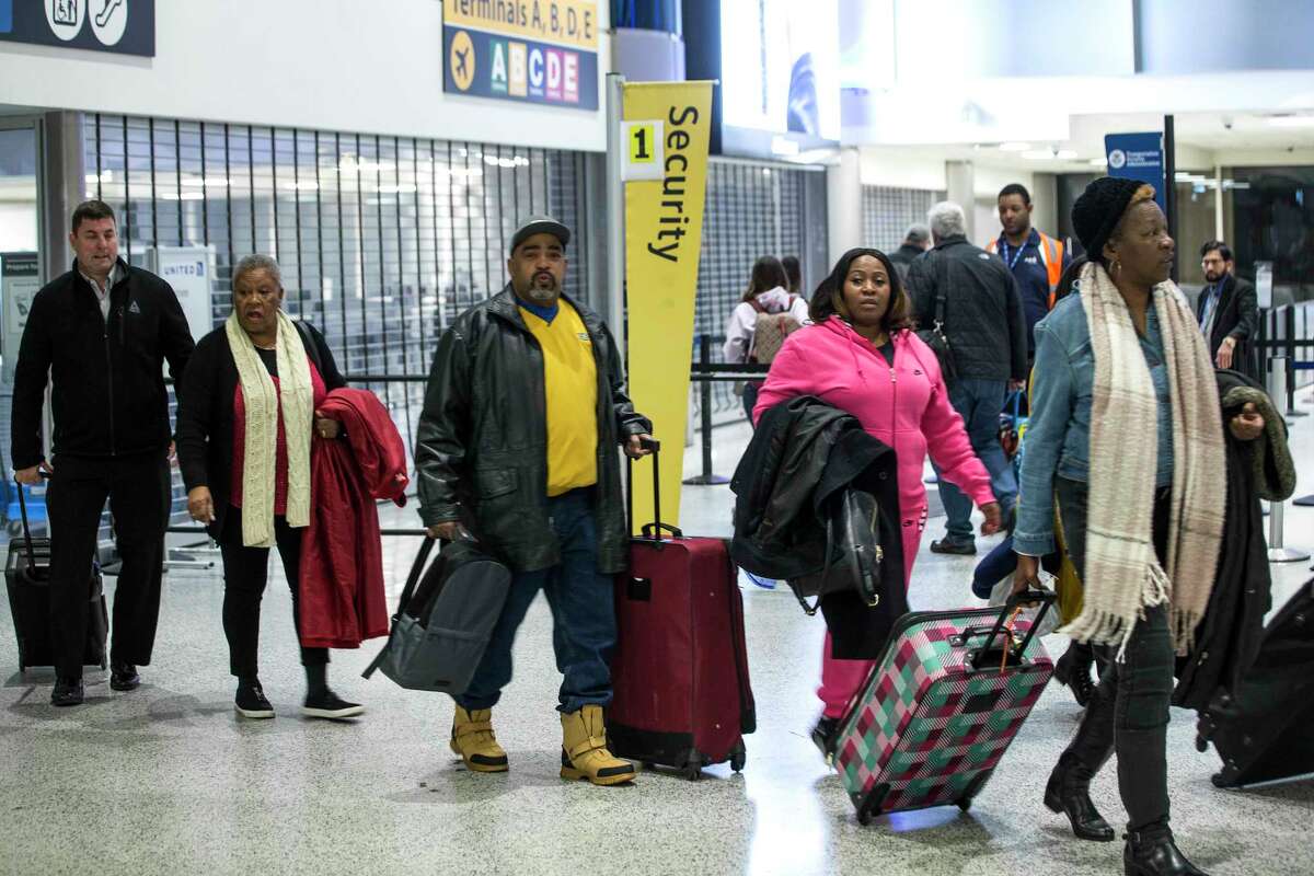 Passengers arrive to Terminal C to check in and go through security at George Bush Intercontinental Airport on Sunday, Jan. 13, 2019, in Houston. The impact of the ongoing government shutdown forced closure of a security checkpoint to Terminal B due to low staffing. Passengers had to be screened at Terminal C and take a train to Terminal B for their flights. Houston Airport System spokesman Bill Begley said “staffing issues” for the decision Transportation Security Administration made at 3:30 p.m. to close the checkpoint for the day.