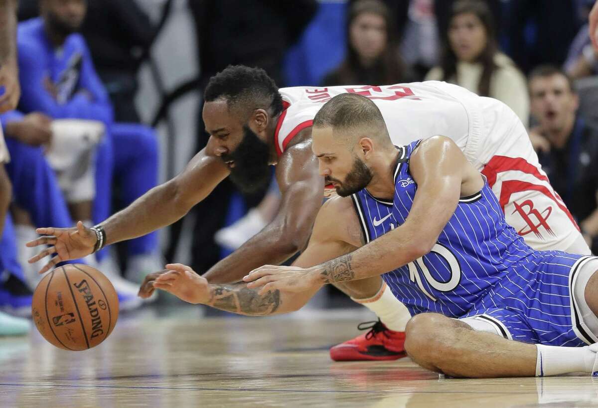 Houston Rockets' James Harden, left, and Orlando Magic's Evan Fournier (10) go after the ball during the second half of an NBA basketball game, Sunday in Orlando, Fla.