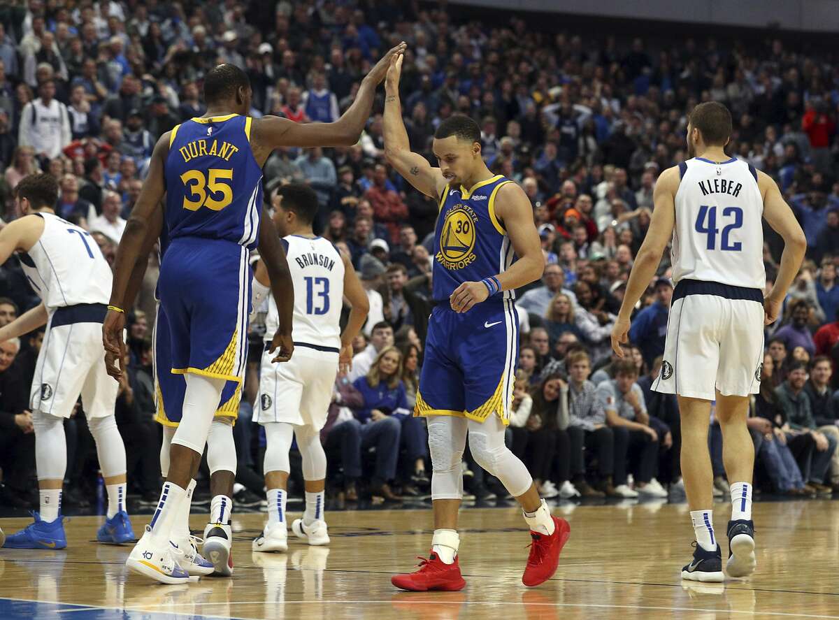 Golden State Warriors forward Kevin Durant (35) high-fives guard Stephen Curry (30) near the end of an NBA basketball game against the Dallas Mavericks, Sunday, Jan. 13, 2019, in Dallas. (AP Photo/Richard W. Rodriguez)