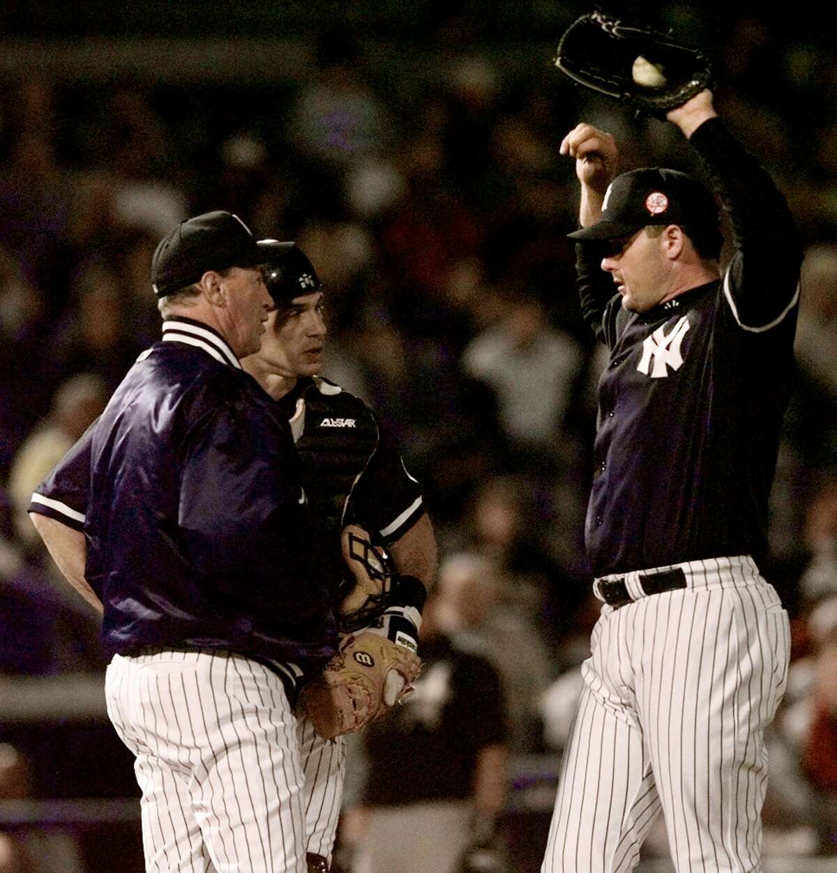 New York Yankees starting pitcher Roger Clemens, right, gets a visit from pitching coach Mel Stottlemyre, left, and catcher Joe Girardi after walking Houston Astros batter Jeff Bagwell with the bases loaded in the second inning Friday, March 26, 1999 at Legends Field in Tampa, Fla. The Yankees lost 7-5. (AP Photo/Ron Frehm)