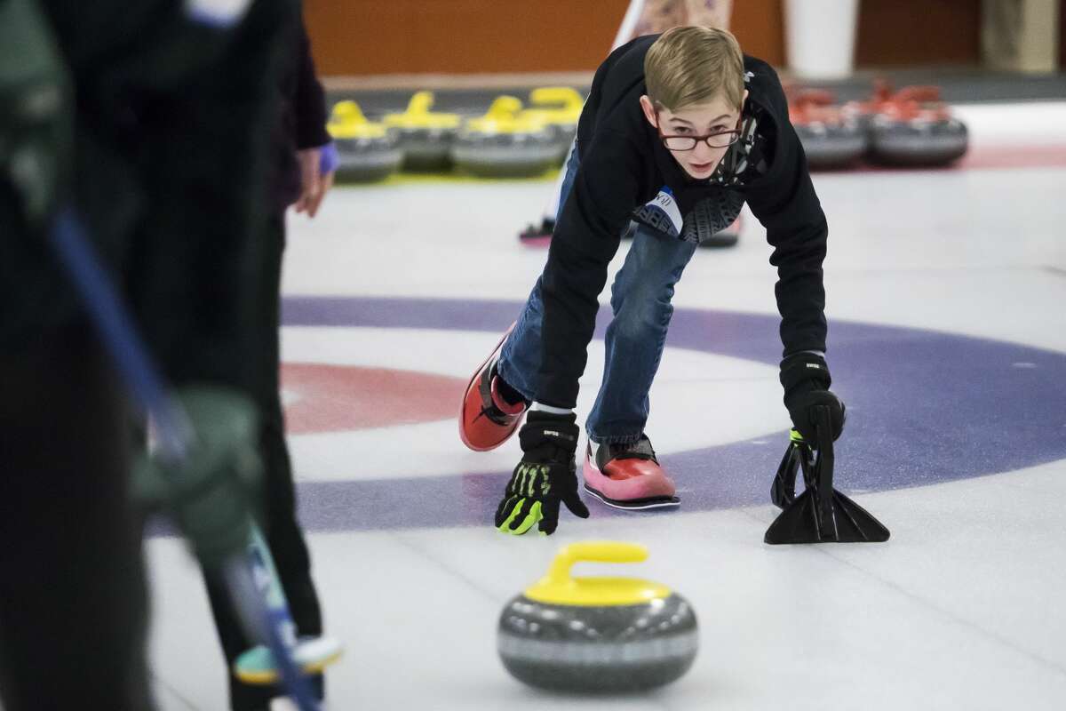William Furlo, 11, practices throwing a stone during an open house at the Midland Curling Club on Saturday, Jan. 12, 2019. (Katy Kildee/kkildee@mdn.net)