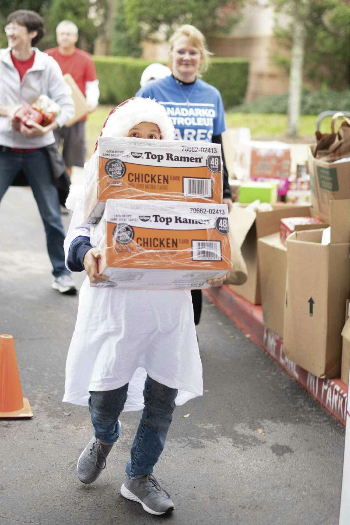 A youngster helps carry food at the Montgomery County Food Bank Holiday Food Drive in December. The Food Bank collected 56,629 pounds of food during the Holiday Food Drive.