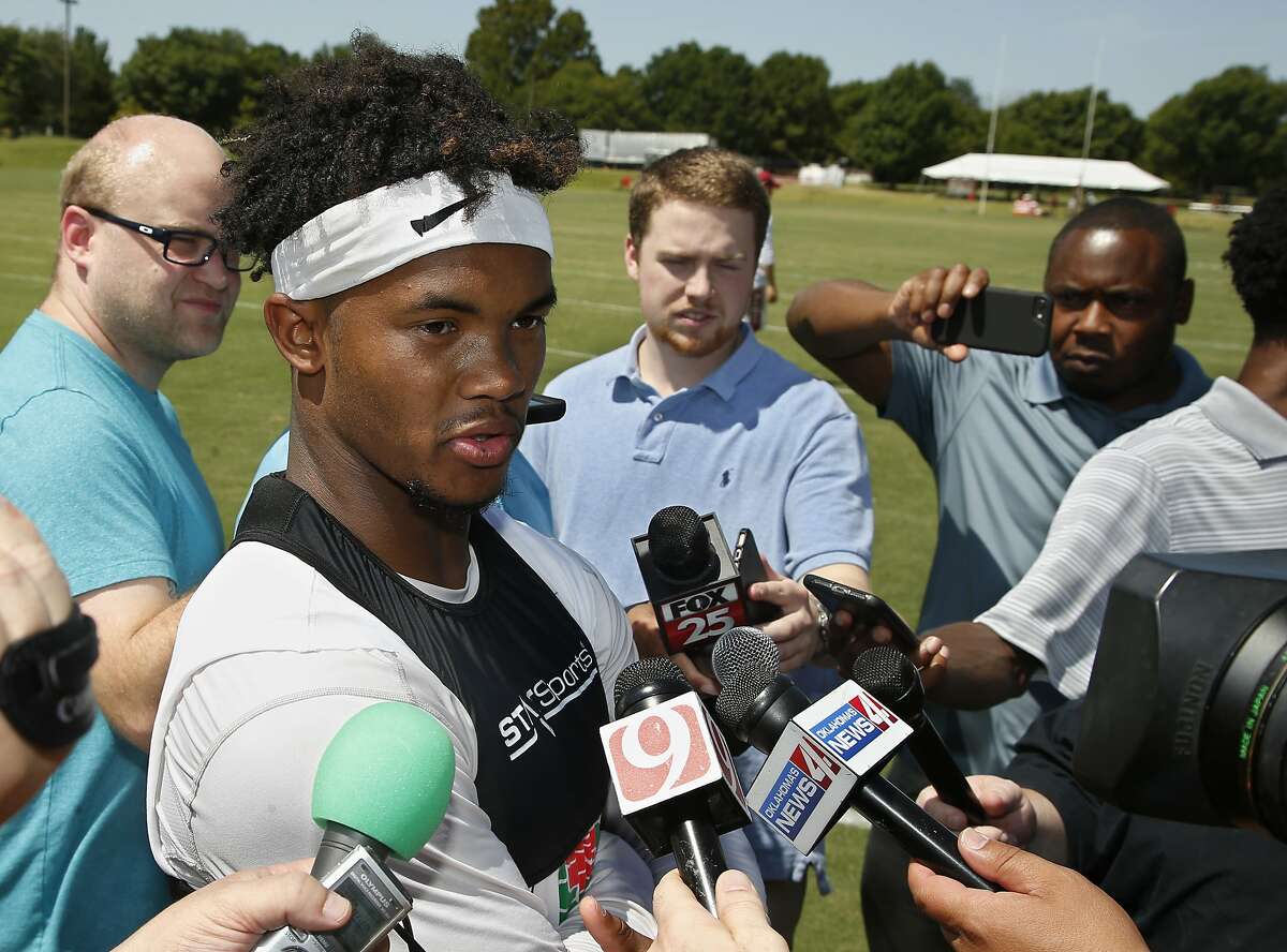 FILE - In this Tuesday, Aug. 7, 2018, file photo, Oklahoma quarterback Kyler Murray talks with the media following an NCAA college football practice in Norman, Okla. The first-round Major League Baseball draft pick has signed for nearly $5 million to play for the Oakland Athletics. Yet, he's fully committed to football for one year, and if he can beat out Austin Kendall for the starting job, the speedster could be one of college football's most electrifying players. (AP Photo/Sue Ogrocki, File)