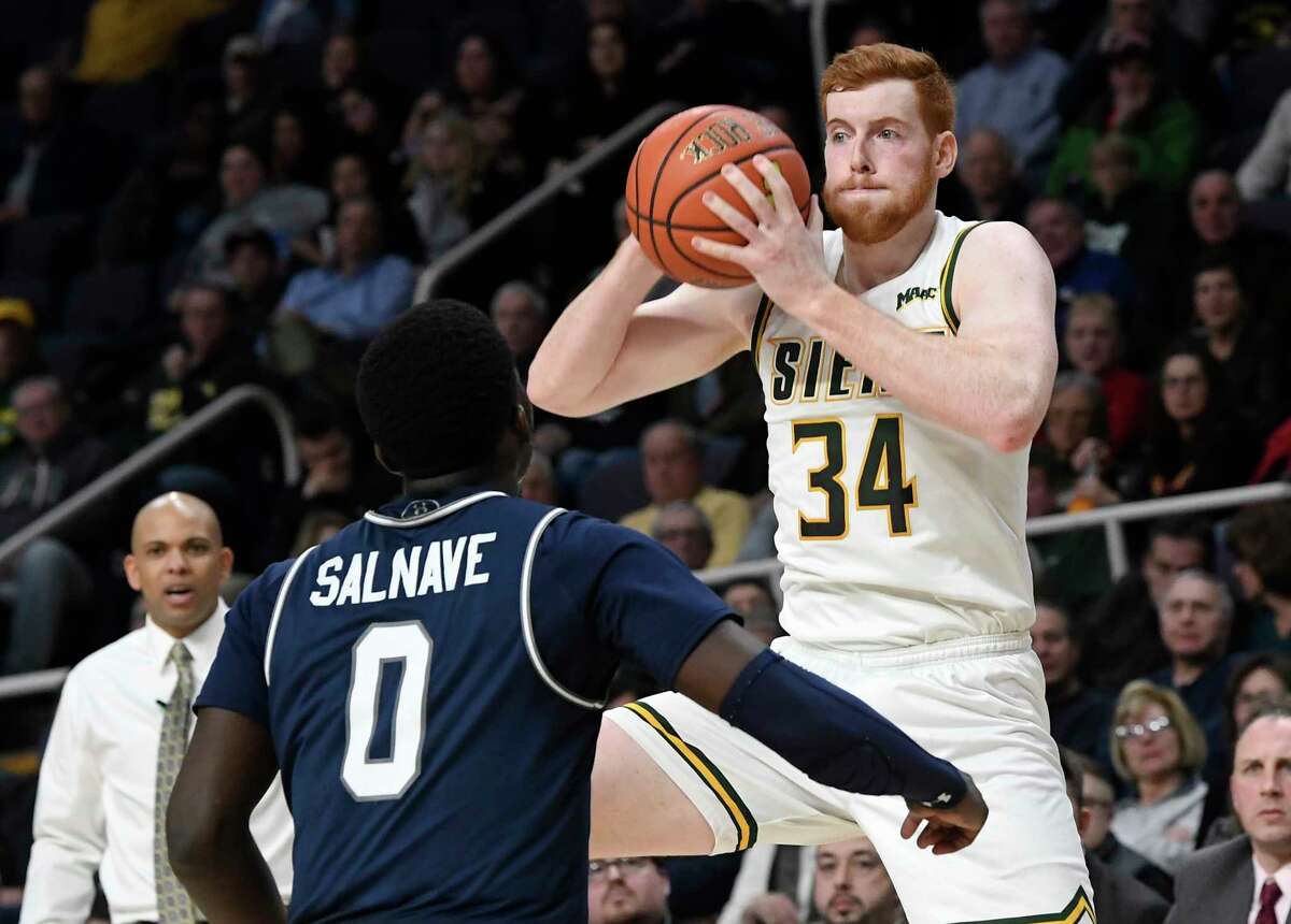 Monmouth guard Ray Salnave (0) defends against Siena forward Kevin Degnan (34) during second half of an NCAA college basketball game Tuesday, Jan. 14, 2019, in Albany, N.Y. Monmouth won 63-60.