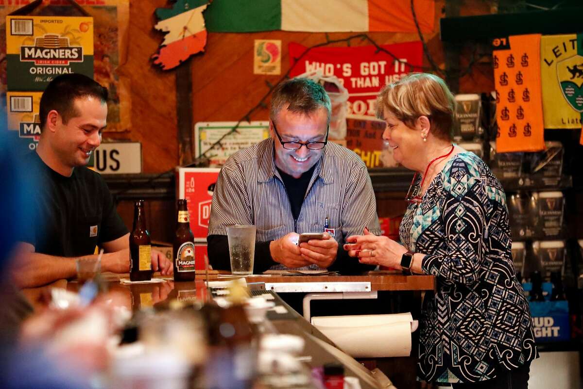 Customers Ed Brennan (center) and Bob Corriea have conversation with bar owner Annie O'Keefe at O'Keefe's in San Francisco, Calif. on Thursday, January 10, 2019.