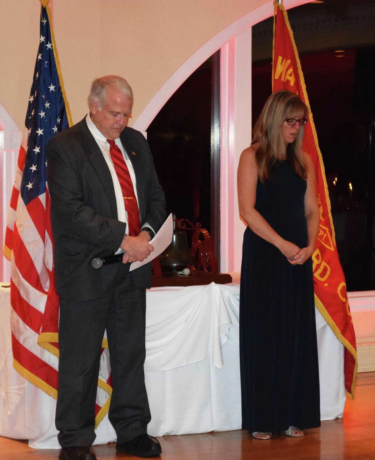 Water Witch President Bill Byrd and Heather Maguire, wife of Water Witch member Patrick Maguire, who died last January, lead the crowd in a quiet moment after Heather rang the bell in memory of those who have died within the past year at Water Witch's annual dinner.