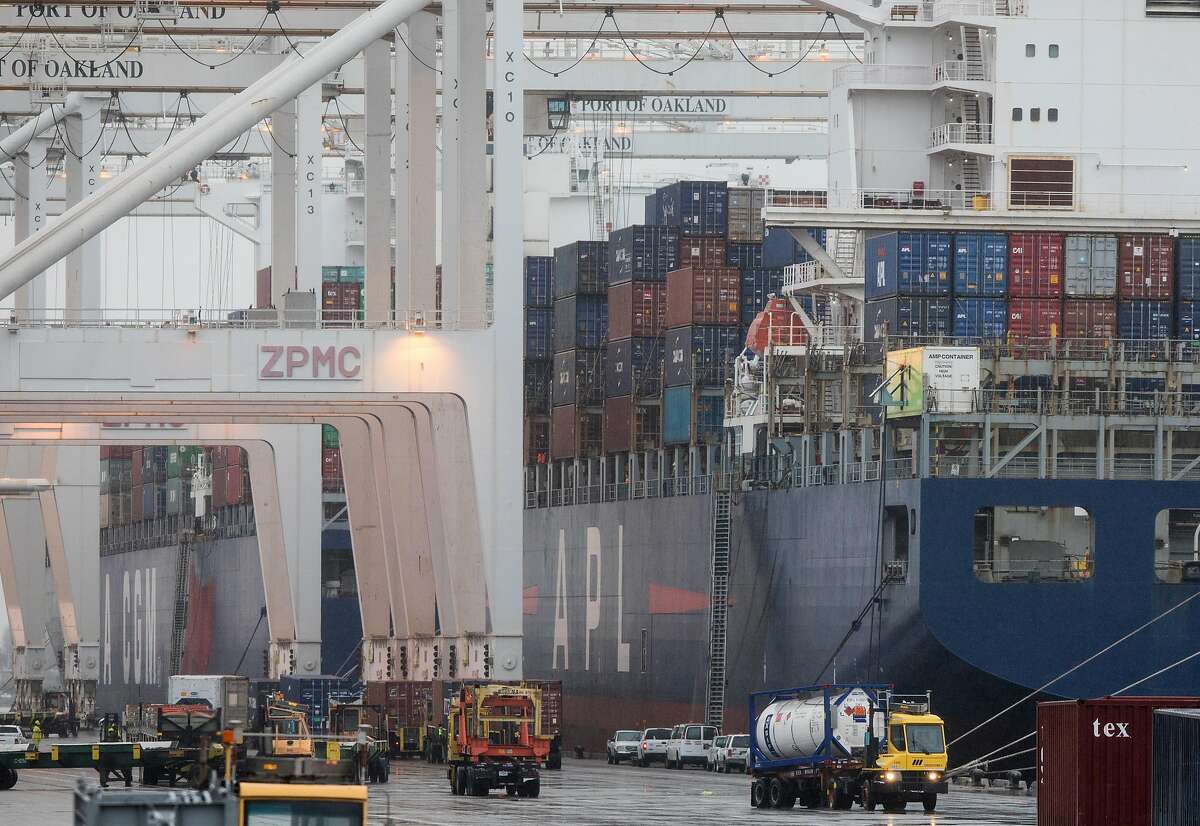 Workers in tractors and trucks move through the yard at the Port of Oakland Oakland, Calif. Tuesday, Jan. 15, 2019.
