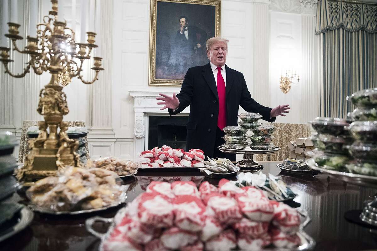 President Donald Trump gives remarks in front of the fast food that was served to the Clemson Tigers, the winners of the 2018 College Football Playoff National Championship, at the White House in Washington, Jan. 14, 2019. The fine dining that is typical for visiting players was substituted with fast food because of the government shutdown, Trump said.(Sarah Silbiger/The New York Times)